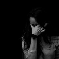 Une femme se tient la tête faisant face à un sentiment d'anxiété.